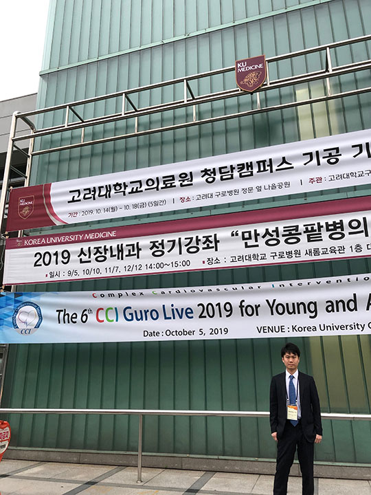 朝到着して横断幕の前に立つ筆者